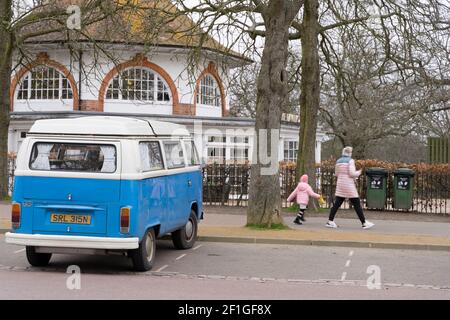 Frauanna und junges Mädchen gehen vorbei VOLKSWAGEN WOHNWAGEN in Blau und weiß geparkt in London greenwich Park Stockfoto