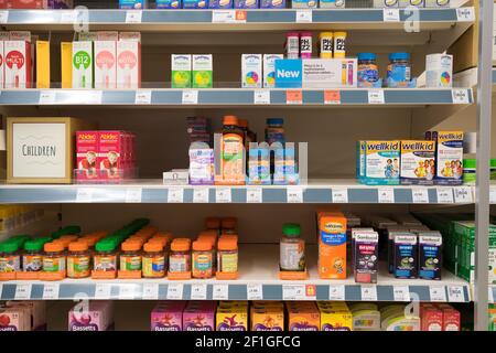 Die Komplementärmedizin von Multivitaminen und Zusatzarzneimitteln für Kinder wird in den Regalen zum Verkauf in Sainsbury's Supermarkt, Großbritannien, ausgestellt Stockfoto