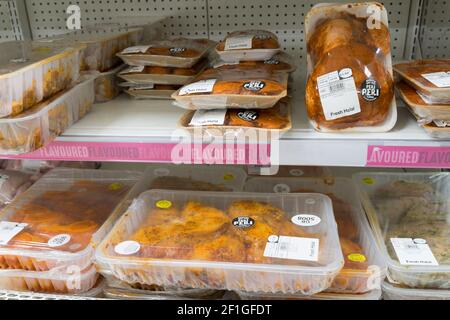 Frisches Halal-Huhn, mariniert in einer Sauce in einem Regal, das in einem Gang in einem Sainsburys-Supermarkt, Großbritannien, verkauft wird Stockfoto