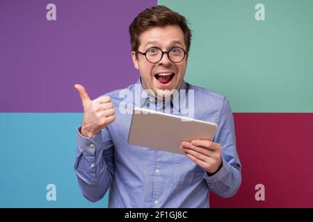 Kaukasischen reifen Geschäftsmann zeigen Daumen nach oben finden interessante Informationen im Internet. Studioaufnahme Stockfoto