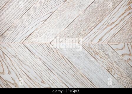 Helle Holzbretter mit heller Textur in Weiß, symmetrisch zueinander in Fischgrätenform angeordnet. Stockfoto