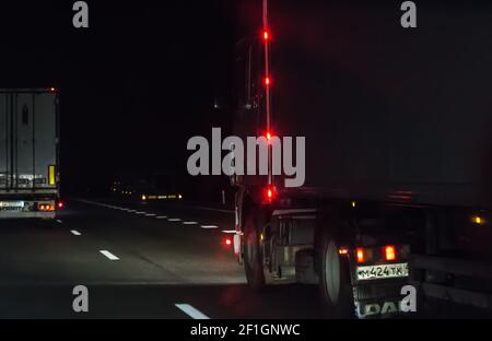 Lastwagen bewegen sich auf einer nächtlichen Autobahn Stockfoto