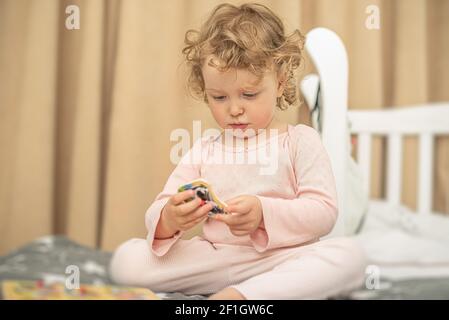 Das Kind spielt mit Spielzeug auf dem Bett Stockfoto