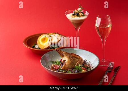 Brunch-Abendmenü. Snack - Scottish Eier, gebratene Wachtel und Dessert - Trio Muss roten Hintergrund. Stockfoto