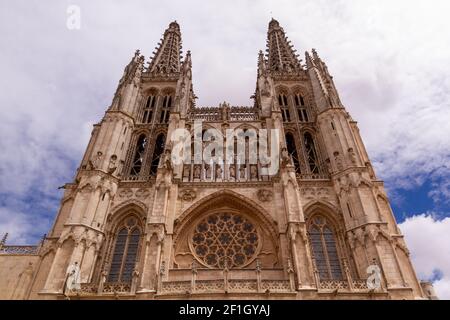 Low-Angle-Aufnahme von Burgos' Kathedrale Hauptfassade und Türme gegen Ein wolkig blauer Himmel Stockfoto