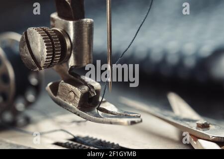 Nahaufnahme der Nähnadel. Schneiderschere auf Arbeitsteil der antiken Nähmaschine. Stockfoto