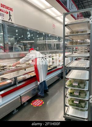 McKinney, TX USA - 22. Februar 2021: Mitarbeiter von Costco Deli stocken die Salatplatten ins Regal Stockfoto