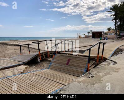 Alicante, Spanien - 8. März 2021: Zerstörte hölzerne Strandpromenade nach schlechtem Wetter mit heftigen Regenfällen und Sturm am Campoamor Strand, Orihiela Costa Stockfoto