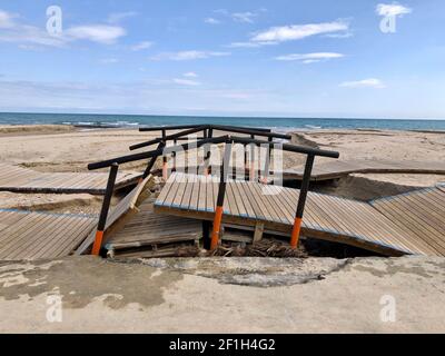 Alicante, Spanien - 8. März 2021: Zerstörte hölzerne Strandpromenade nach schlechtem Wetter mit heftigen Regenfällen und Sturm am Campoamor Strand, Orihiela Costa Stockfoto