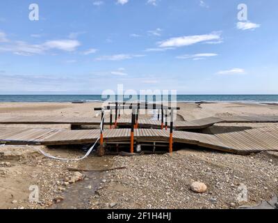 Alicante, Spanien - 8. März 2021: Zerstörte hölzerne Strandpromenade nach schlechtem Wetter mit heftigen Regenfällen und Sturm am Campoamor Strand, Orihiela Costa Stockfoto