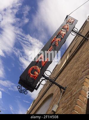 Neon Parkplatz Schild auf schwarzem Hintergrund auf Ziegel montiert Stockfoto
