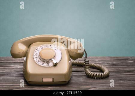 Alte Telefonanlage aus den 70s des 20th. Jahrhunderts Steht auf den Holzbrettern isoliert auf einem blauen Hintergrund Stockfoto