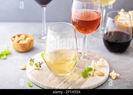 Rot, Weißwein und Rose in verschiedenen Gläsern Stockfoto