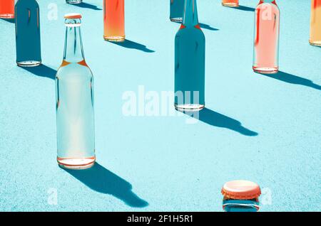 3D Modelle von Glas-Bierflaschen mit Deckel und ohne Etiketten. Schatten auf hellblauer Oberfläche. Retro Getränkeflasche Konzept. Stockfoto