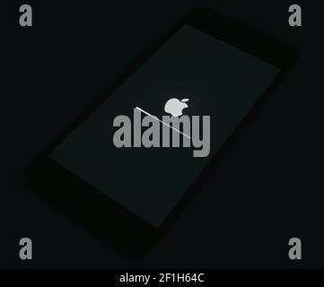 2020: IOS laden auf dem Apple iPhone Schwarzer Startbildschirm, isoliert in der Dunkelheit Stockfoto