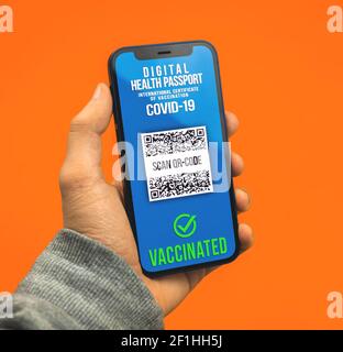 Mann hält Smartphone mit Gesundheitspass Anwendung, gültige COVID-19 Testergebnis Stockfoto