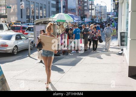 USA, New York, NY - Fußgänger und Huthändler am späten Nachmittag auf der Canal Street. Stockfoto