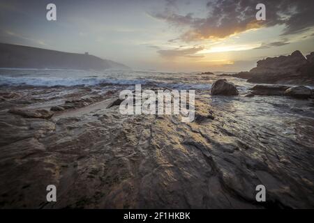 Sonnenuntergang in Tagle Strand. Panoramablick auf schöne bunte riesige Felsen und Meer auf der Rückseite. Kantabrien. Spanien. Stockfoto