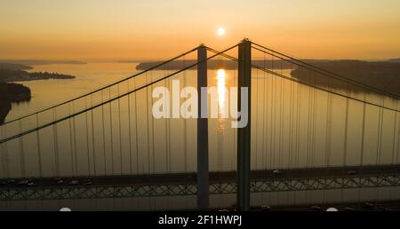 Sonne geht zum Horizont über Tacoma Narrows Bridges Stockfoto