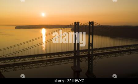 Sonne geht zum Horizont über Tacoma Narrows Bridges Stockfoto
