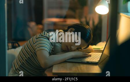 Die Asiatin schlief ein, als sie versuchte, die Arbeit zu beenden Nachts Stockfoto