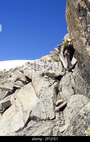 Männlicher Bergsteiger auf einer steilen Felswand auf seinem Weg zum berühmten Eiger in den Schweizer Alpen Stockfoto