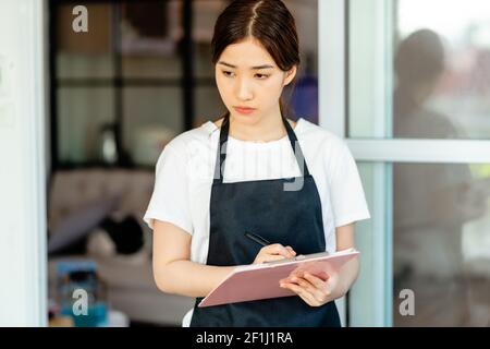 Die asiatische Kellnerin überprüft das Hotelzimmer nach den Gästen Abreise Stockfoto