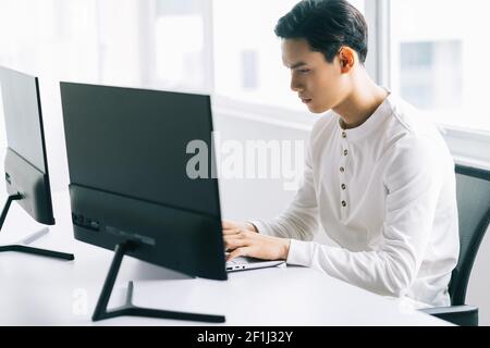 Asiatische Programmierer sind auf die Arbeit konzentriert, um die zugewiesenen zu erfüllen Fristen Stockfoto