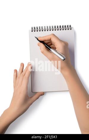 Frau hält Stift und Schreiben in Notebook Stockfoto