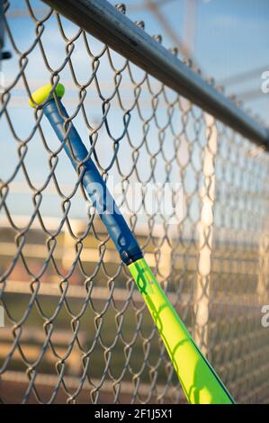 T-Ball Baseballschläger hängen auf dugout Kettenglied Zaun Stockfoto