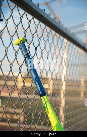 T-Ball Baseballschläger hängen auf dugout Kettenglied Zaun Stockfoto