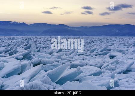 Endloses Bummockfeld am gefrorenen Baikalsee. Haufen von schneebedeckten Trümmern von blauem Eis an einem frostigen Tag. Kalter natürlicher Hintergrund. Ungewöhnlicher Winter Stockfoto
