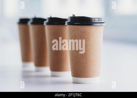 Vier Tassen Kaffee werden in einer Reihe auf gelegt Die Tabelle Stockfoto