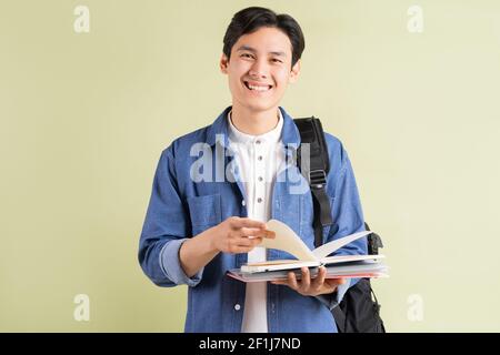 Foto von schönen asiatischen Studenten lächeln und halten Buch in Hand Stockfoto