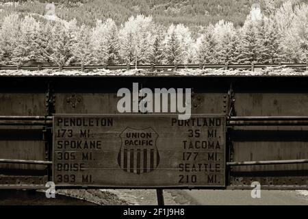 Ein Schild auf einer Eisenbahnbrücke bei Multnomah Falls, Oregon, zeigt die Kilometerzahl zu mehreren nordwestlichen Städten an. Stockfoto