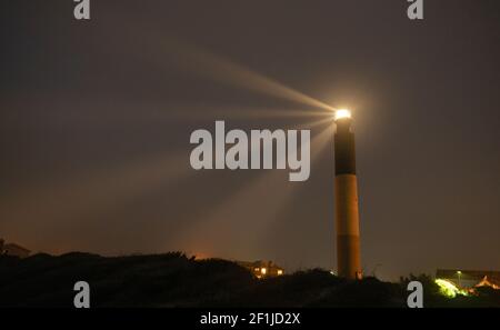 Oak Island Lighthouse strahlt in die Seafoam in Fort Caswell Stockfoto