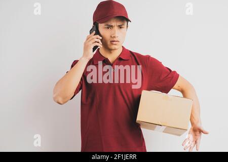 Portrait eines Lieferers, der einen Frachtschachtel hält und Hören des Telefons im Hintergrund Stockfoto