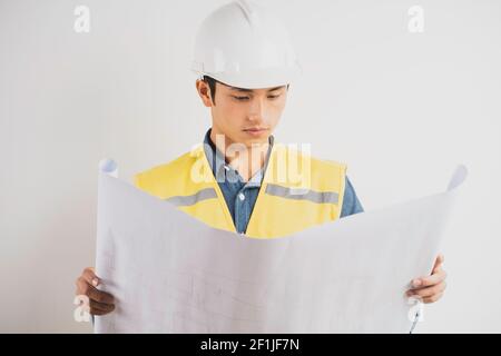 Asiatischer Bauingenieur beim Lesen der technischen Zeichnung Stockfoto