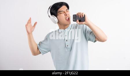 Der asiatische Mann hörte Musik, während er mitsang Stockfoto