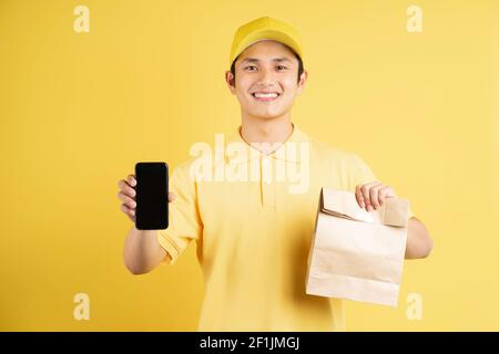 Porträt eines männlichen Lieferers mit Einkaufstasche und Telefon Stockfoto