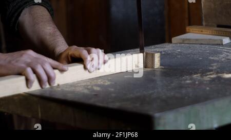 Zimmermanndetail schneidet ein Stück Holz mit einem Band Säge Stockfoto