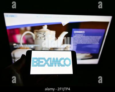 Person, die Smartphone mit Logo von Bangladesh Export Import Company Limited (BEXIMCO) auf dem Bildschirm vor der Website hält. Konzentrieren Sie sich auf die Telefonanzeige. Stockfoto