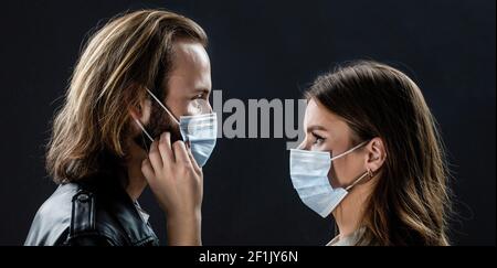 Paar trägt eine schützende Gesichtsmaske, Pandemie und Gefühle Konzept. Lifestyle COVID-19. Gesichter von Menschen in Schutzmasken von Coronavirus Stockfoto
