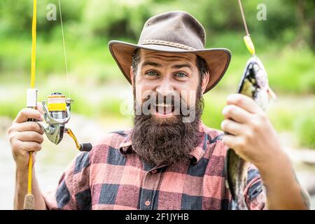 Mann hält große Fischforelle in den Händen. Fischer und Trophäe Forelle. Mann, der einen Forellenfisch hält. Angeln. Angler mit Angeltrophäe. Fischer und Forelle Stockfoto