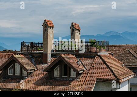 Blick auf altes Haus mit Dachterrasse und Garten In Europa mit Berglandschaft dahinter Stockfoto