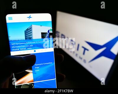 Person mit Smartphone-Website-Logo des US-Luftfahrtunternehmens Spirit Aerosystems Inc. Auf dem Bildschirm vor dem Logo. Fokus auf der Mitte des Telefondisplays. Stockfoto