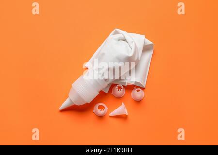 Gebäckbeutel und verschiedene Tipps auf farbigem Hintergrund Stockfoto