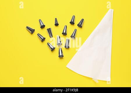 Gebäckbeutel und verschiedene Tipps auf farbigem Hintergrund Stockfoto