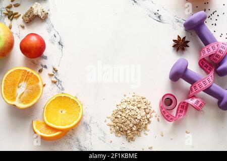 Gesunde Produkte, Hanteln und Gewürze auf hellem Hintergrund Stockfoto