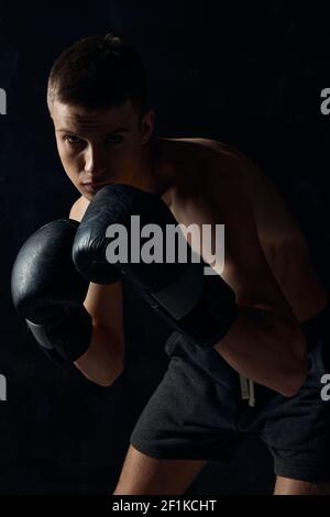 Mann in Boxhandschuhen auf schwarzem Hintergrund Workout Bodybuilder Fitness Stockfoto